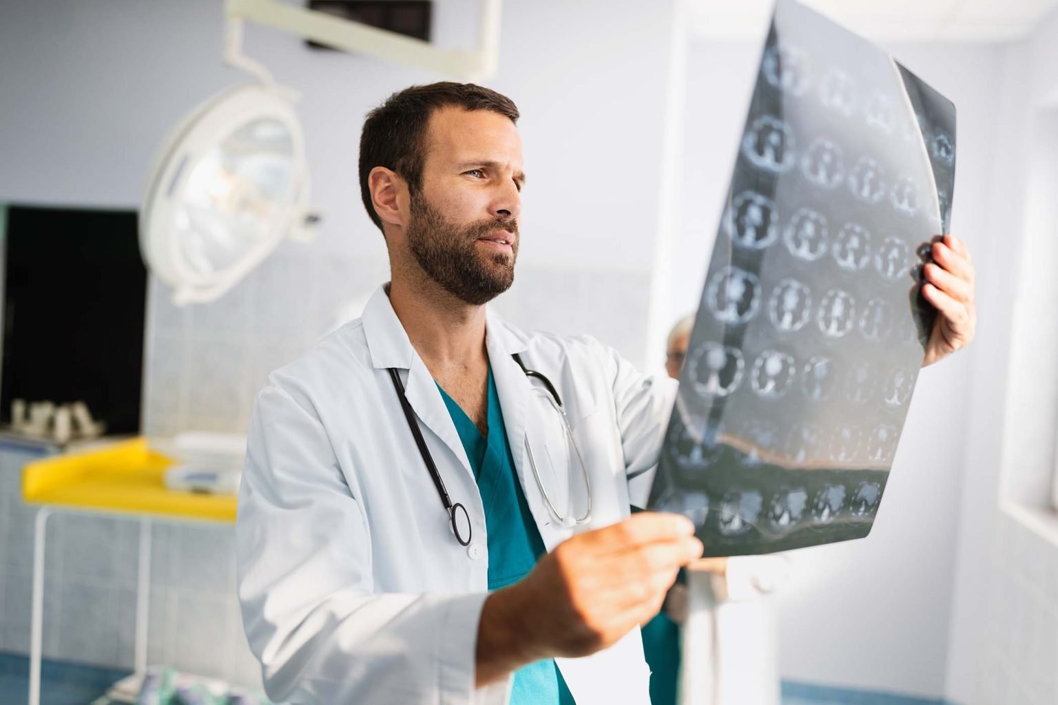 portrait-of-young-doctor-checking-x-ray-in-hospita-7HYYJ6T-1536x1024